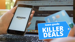Amazon check out screen in front of phone and laptop with credit card in hand and killer deals badge