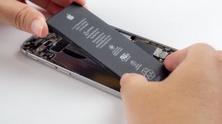 Close-up image of Technician hands tried to remove, take of, change or replace Apple iPhone 6 battery degenerate or damage.