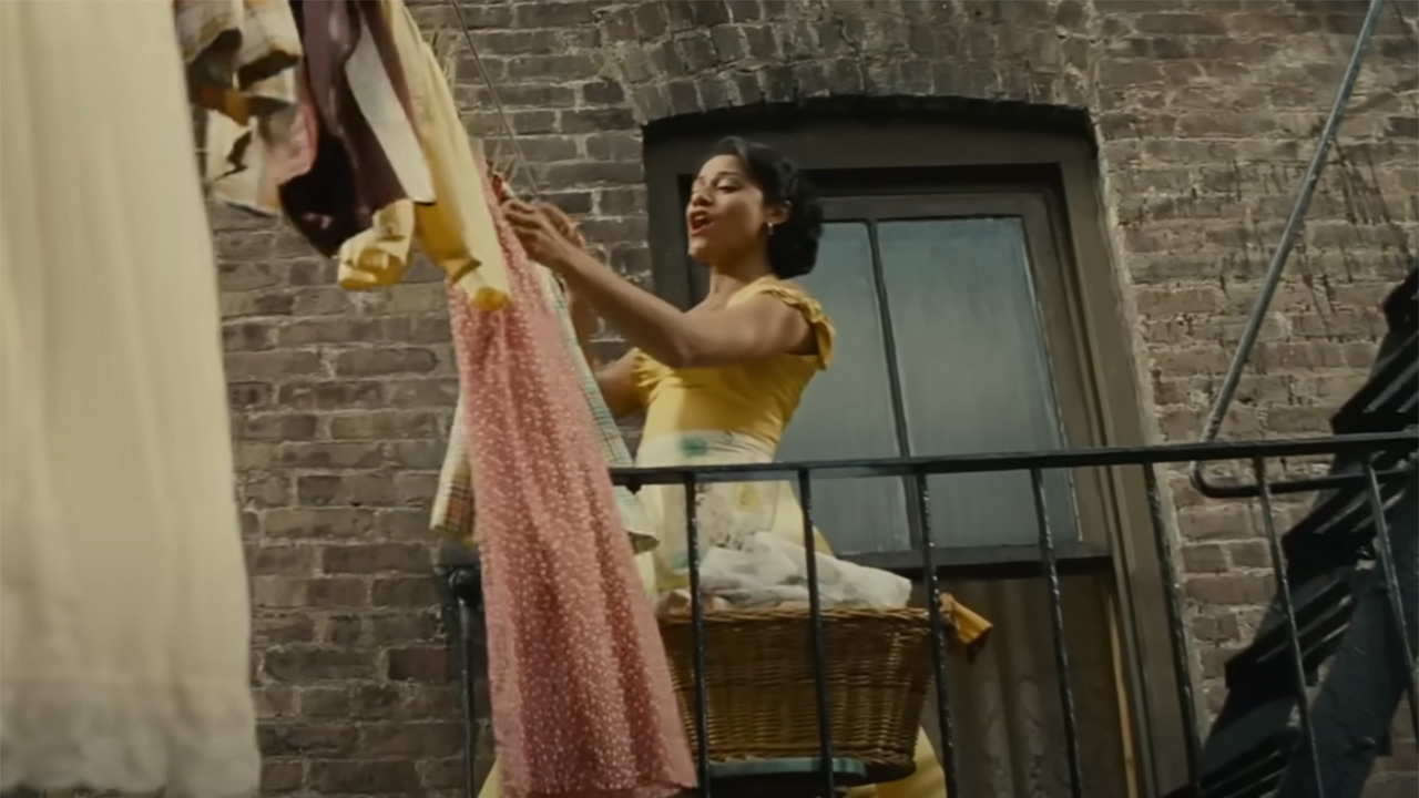 Ariana DeBose in her yellow dress in West Side Story scene.