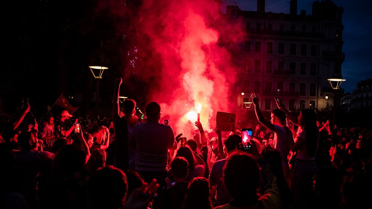 Left wing supporters light red flares as they celebrate during a rally after the announcement of the results of the second round of France&#039;s parliamentary elections