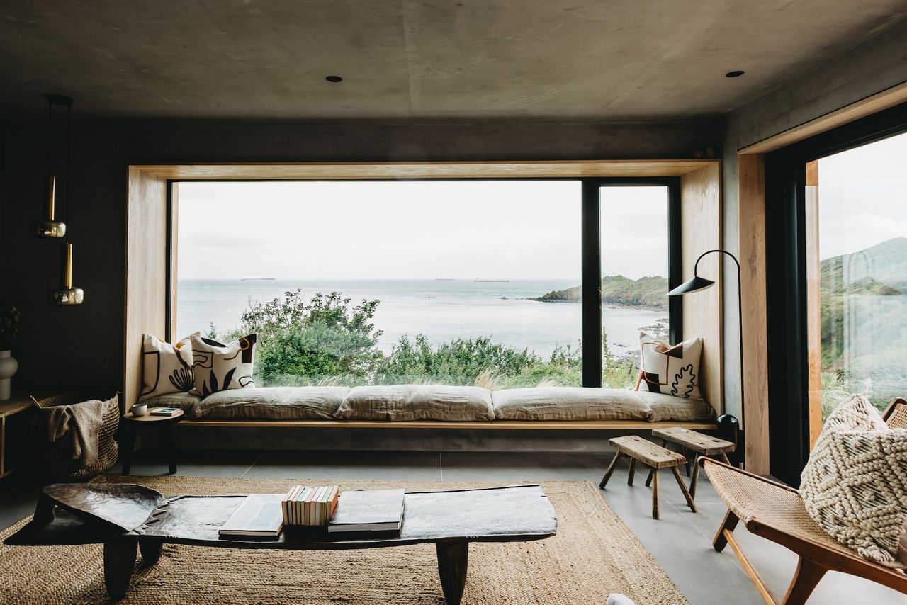 living room with wide window over looking sea and coast