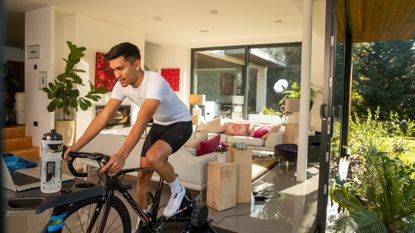 Image shows Sam Gupta riding indoors on a turbo trainer