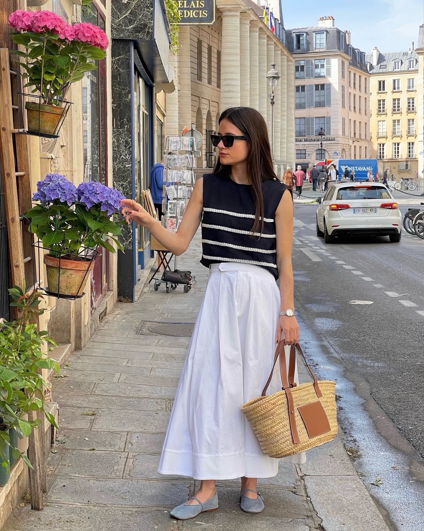 woman wears basket bag with white skirt