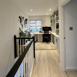 hallway with white wall work desk and chair window and wooden floor