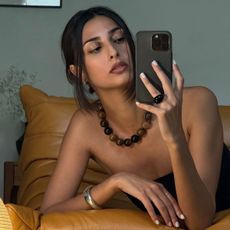 A photo of Salome Mory taking a selfie in the mirror with her phone