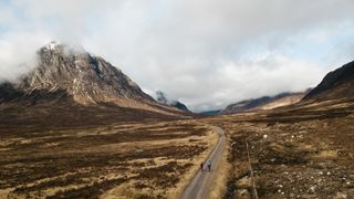 Two gravel riders on the West Highland Way entering Glencoe, with Buachaille Etive Mòr in background