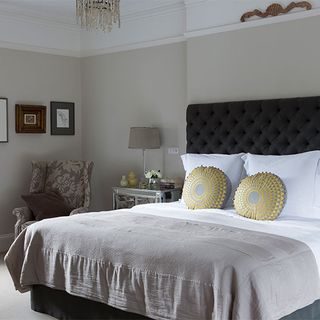 main bedroom with grey wall and pillows on bed