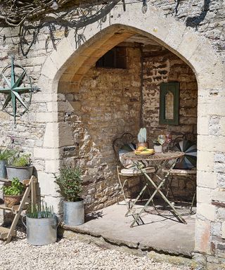 exterior with arch with bistro set in 12th century Cotswolds country house
