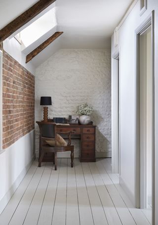 brick hallway with wooden desk and chair