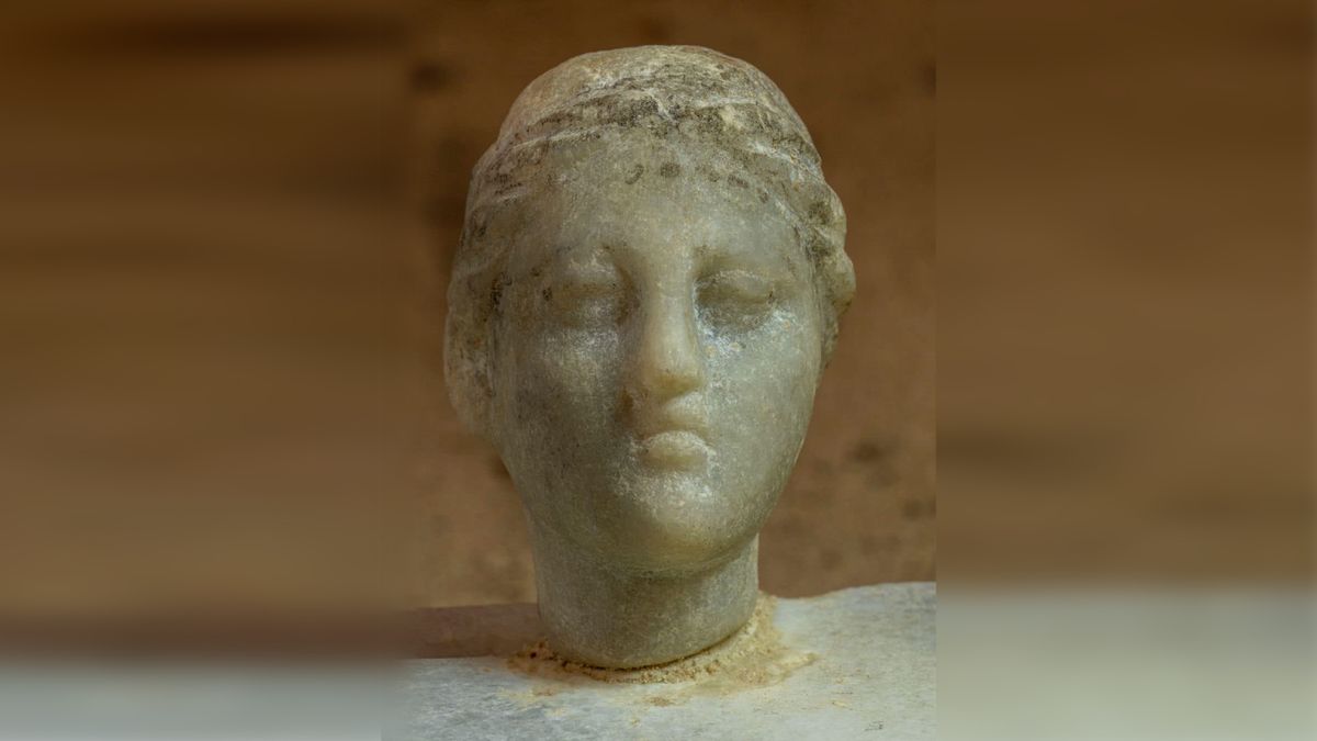 A small bust of a woman, possibly Cleopatra, in white marble