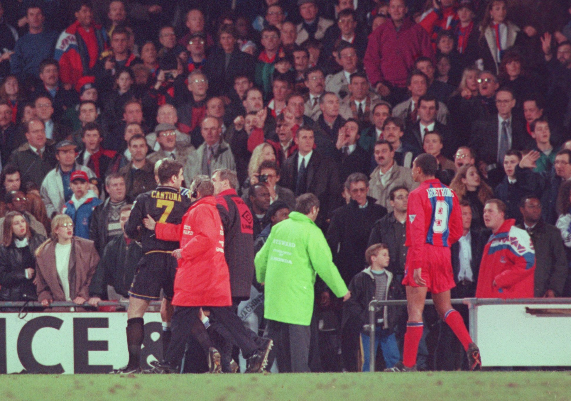 Manchester United's Eric Cantona is led off the pitch after kicking an abusive Crystal Palace fan in a game in January 1995.