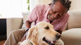 Senior man with pet labrador, looking happy