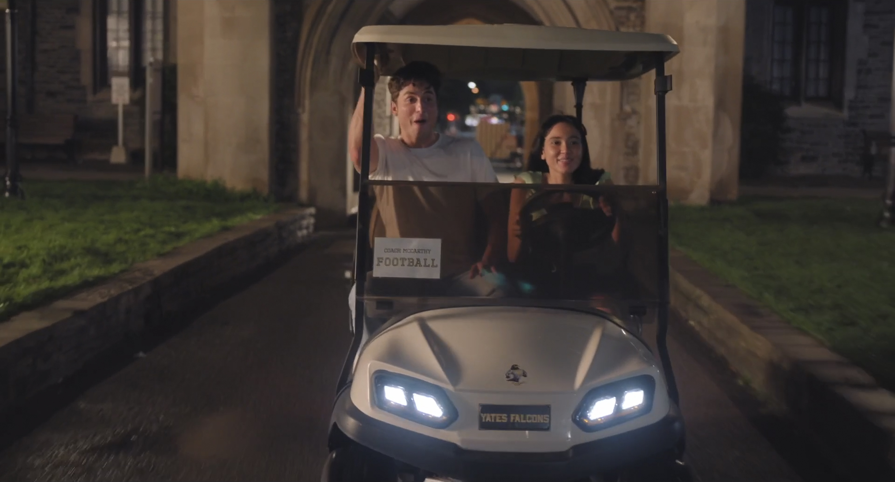 benito skinner as benny and wally baram as carmen riding in a golf cart on campus in overcompensating