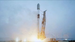a white and black rocket lifts off into an overcast sky
