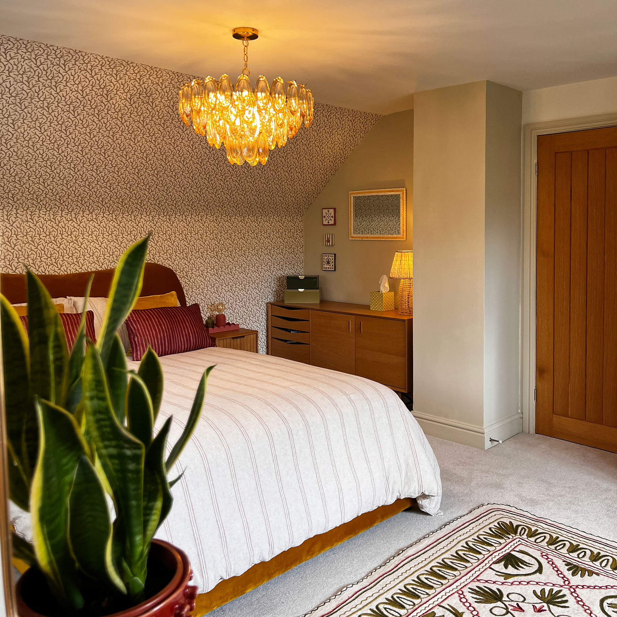 Bedroom with chandelier style pendant light above double bed