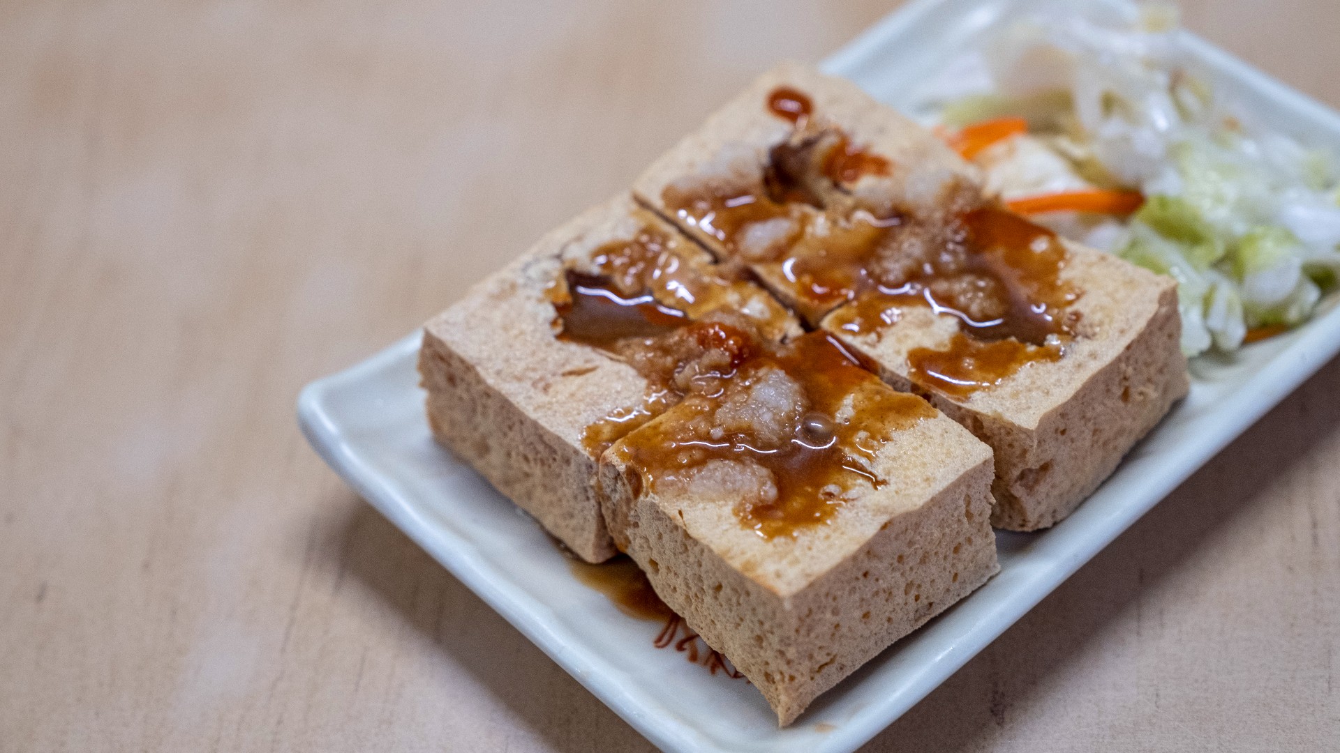 Tofu on a plate with sweet chilli sauce on top