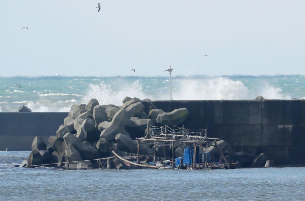 The wreckage of a North Korean fishing boat is pictured along a sea wall in the city of Yurihonjo, Japan