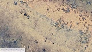 A satellite image of a desert with spiral marks across it