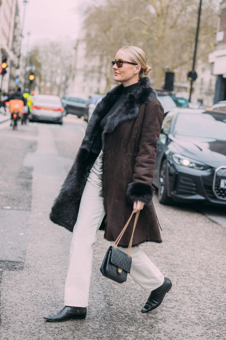 A guest attending shows during London Fashion Week wearing jeans with ankle boots.