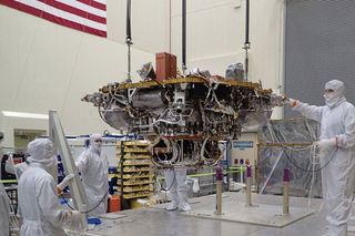 Technicians lift the lander portion of the InSight spacecraft for testing in a clean room facility in Littleton, Colorado. The probe is set to launch to Mars in May 2018.