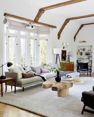 A modern rustic living room with wooden beams and rustic decor including carved wooden coffee table