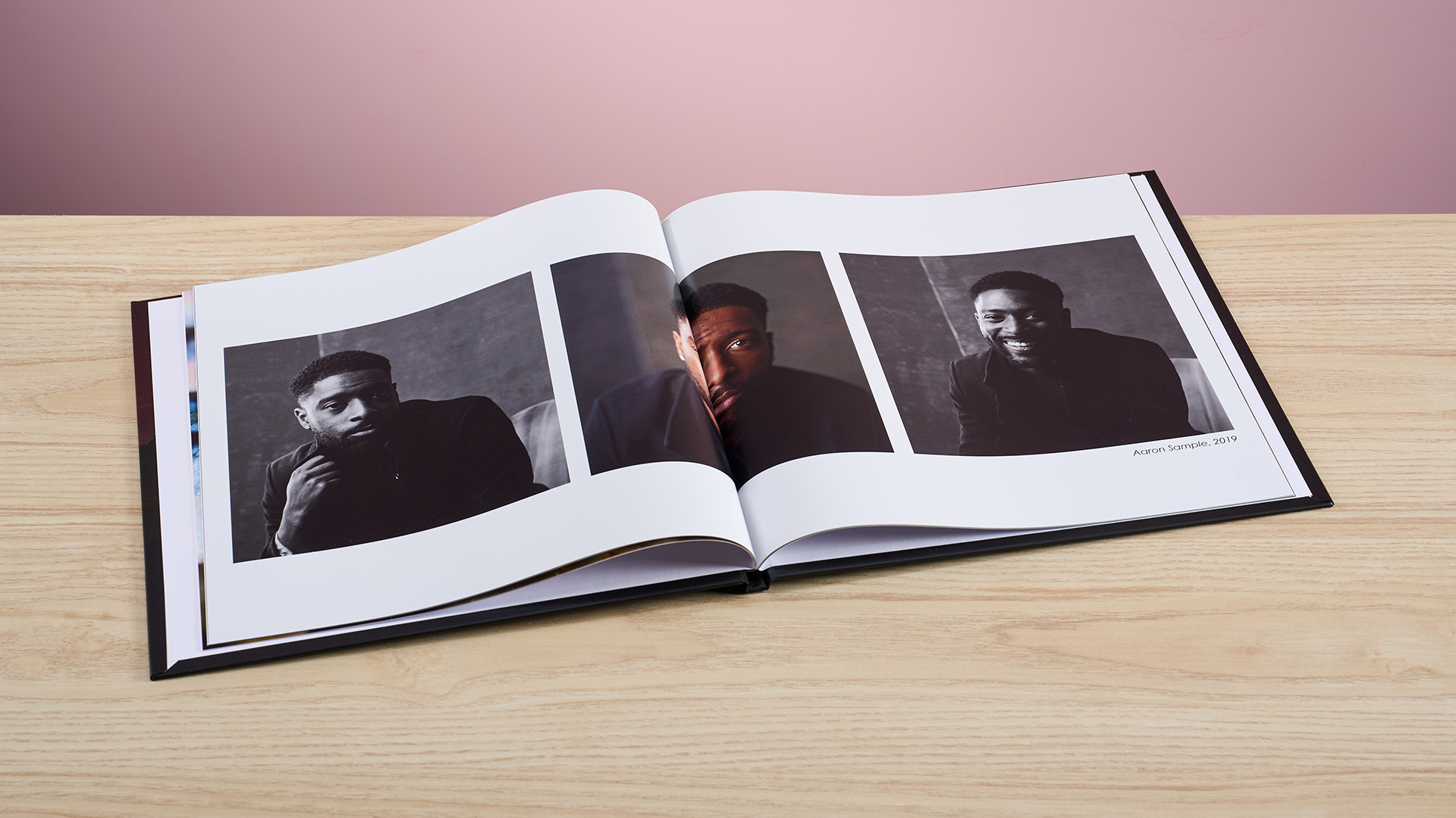 The Mixbook photo book sits open, turned to pages featuring three profile shots, the middle image distorts into the binding.