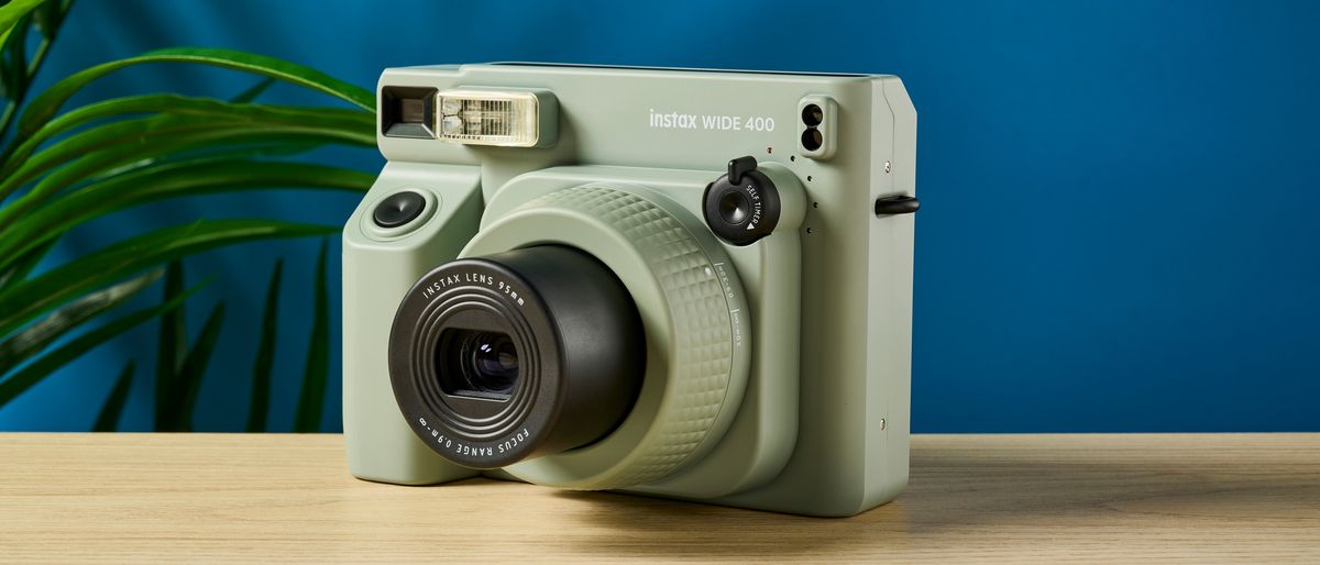 A sage green Fujifilm Instax Wide 400 instant camera