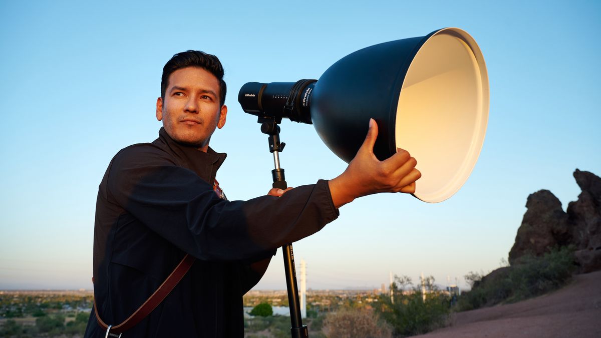 Man attaching Profoto Hard Reflector White modifier to a Profoto monolight