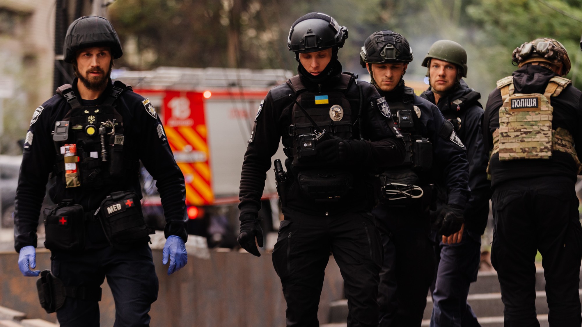 soldiers in protective gear walk towards medics