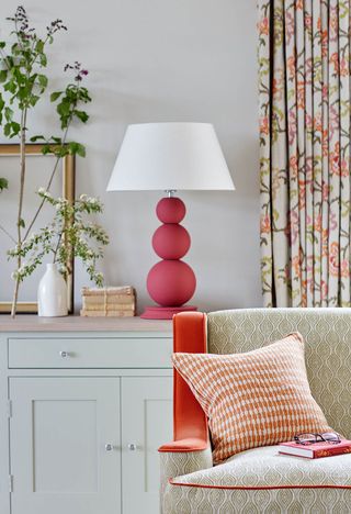 Red lamp on table behind sofa