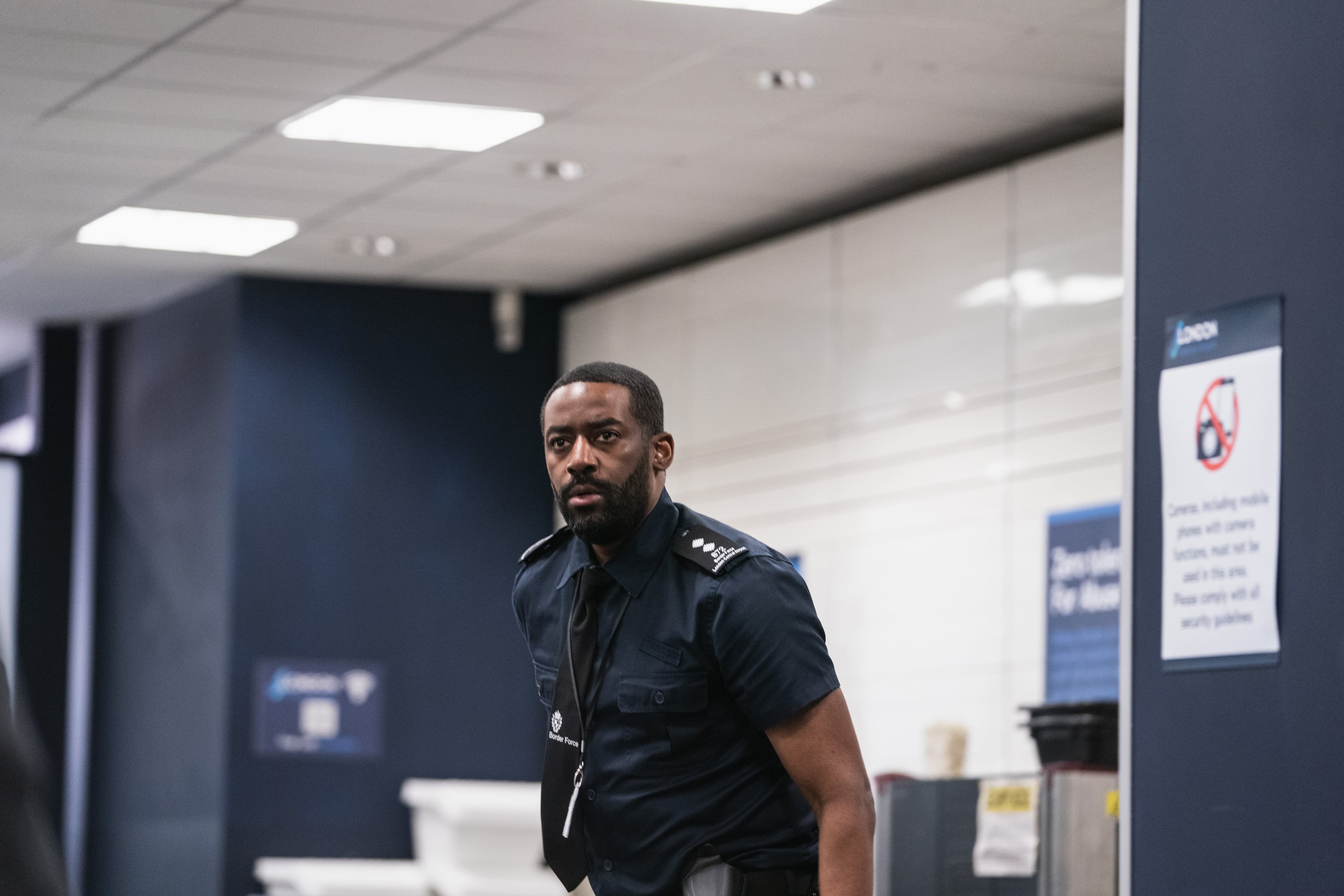 Ashley Thomas as customs officer Dom.