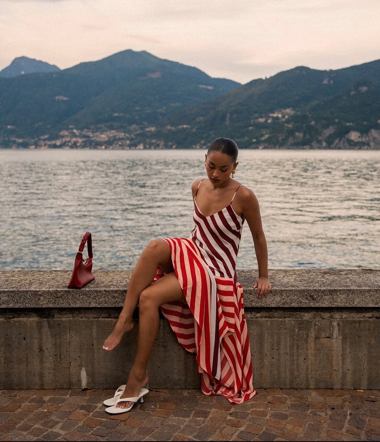 aanisha gurung wears a striped maxi dress and white heeled sandals