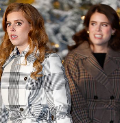 Princess Beatrice wearing a plaid coat and Princess Eugenie wearing a brown wrap coat in front of a flocked Christmas tree