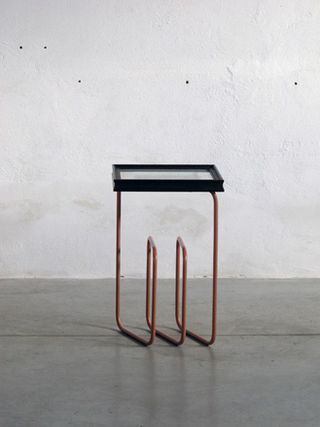 Side table with black framed glass top and copper tubing legs