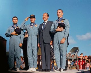 At April 18, 1970 post-mission ceremonies, President Richard M. Nixon and the Apollo 13 crew pay honor to the United States flag at Hickam Air Force Base in Hawaii. Nixon presented astronauts Jim Lovell (seen here saluting the flag), Jack Swigert (right) and Fred Haise (left) with the Presidential Medal of Freedom.