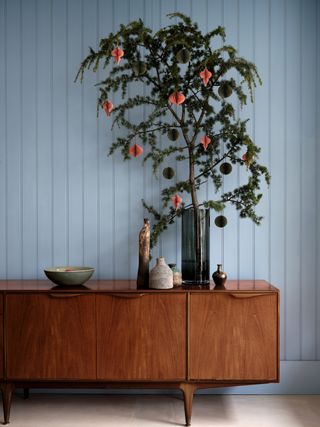 Christmas entryway with branches decorated with baubles by Farrow & Ball