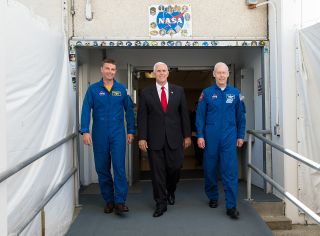 NASA’s incoming and outgoing chief astronauts, Reid Wiseman (at left) and Patrick Forrester (at right) accompany Vice President Mike Pence out of the Neil A. Armstrong Operations & Checkout Building at Kennedy Space Center in July 2017.