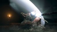 A warrior in mid-swing battles a monstrous creature, emitting a bright arc of light. A torch flickers in the dark, adding intensity to the scene.