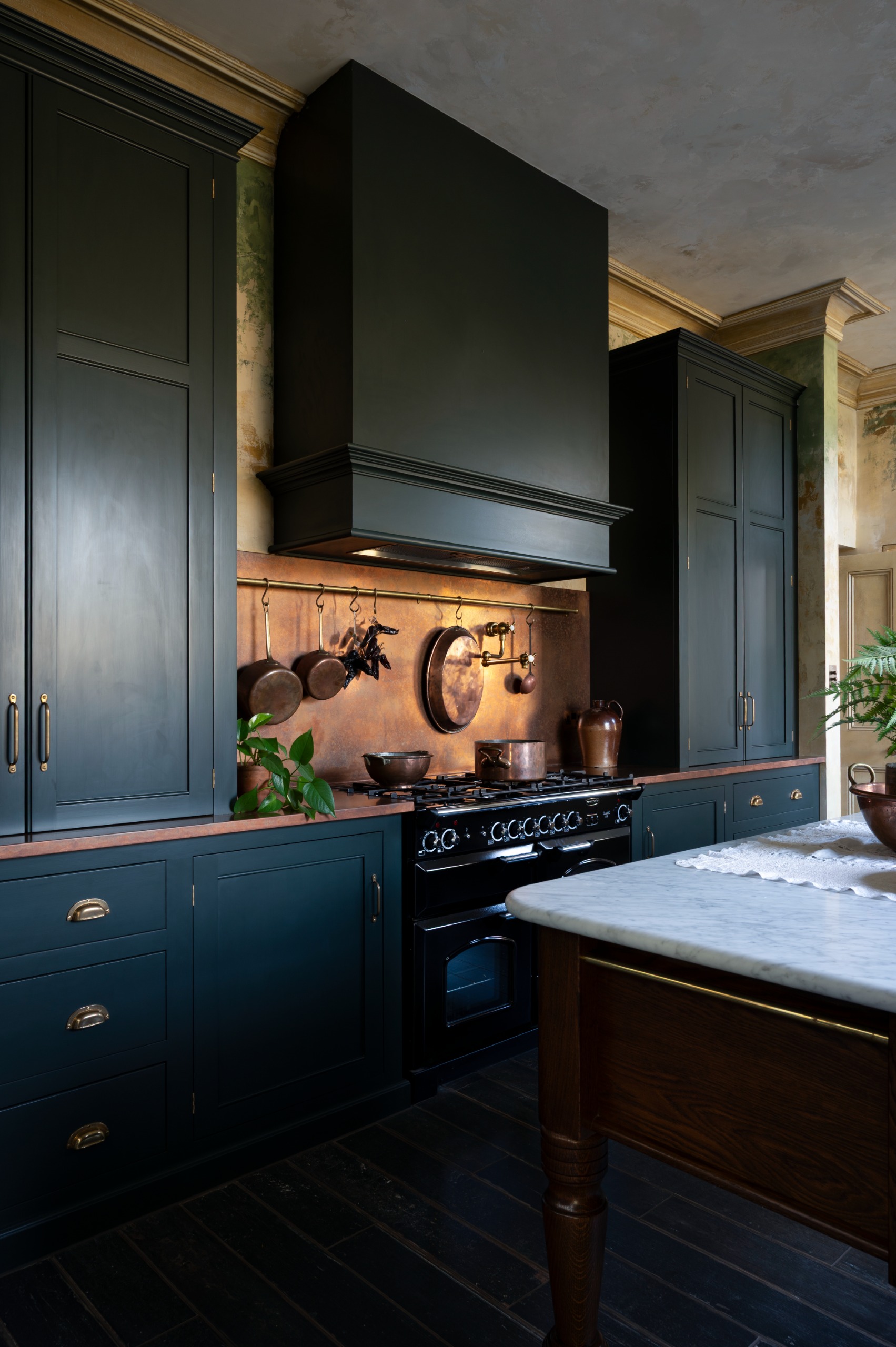 traditional kitchen with navy cabinets and a copper backsplash