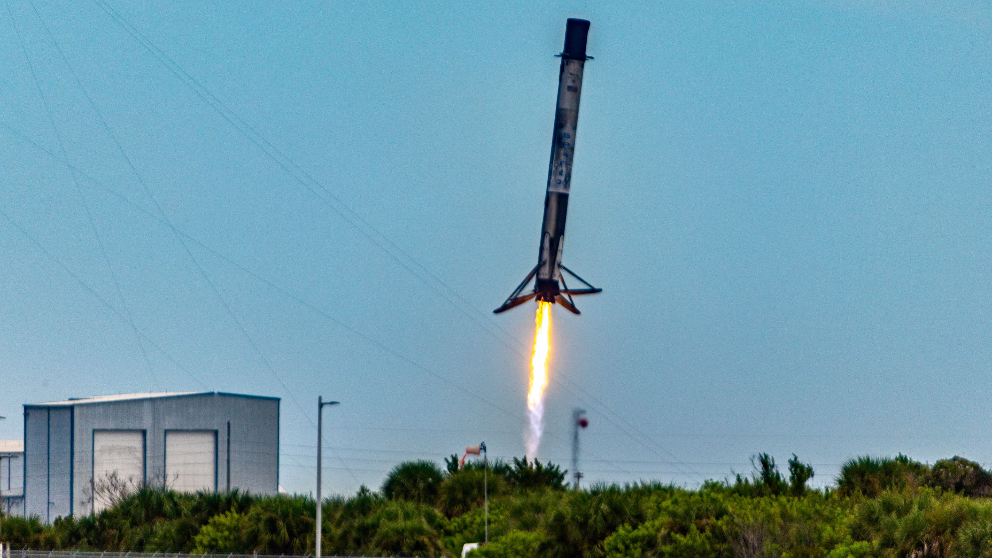 A SpaceX Falcon 9 rocket comes in for landing covered in soot