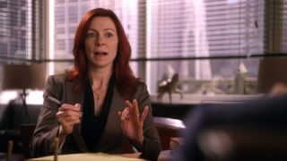 Carrie Preston talking with both her hands, and holding a pen in her left hand on The Good Wife.