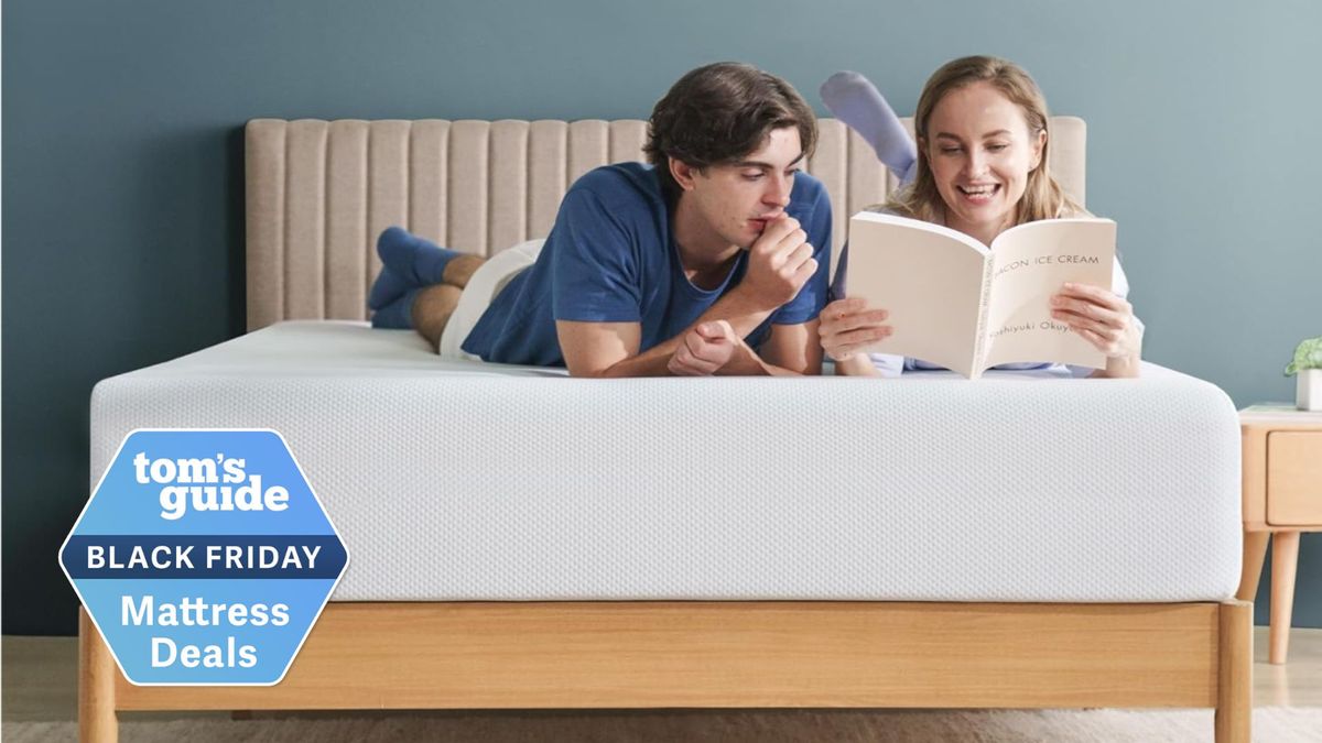 A man and woman looking at a book while laying on their fronts on king size 12 inch Zinus Green Tea Cooling Memory Foam mattress