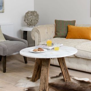 travertine table with wooden flooring and sofa set with cushion