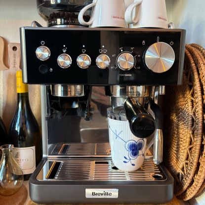 Breville coffee machine with blue mug on a kitchen countertop