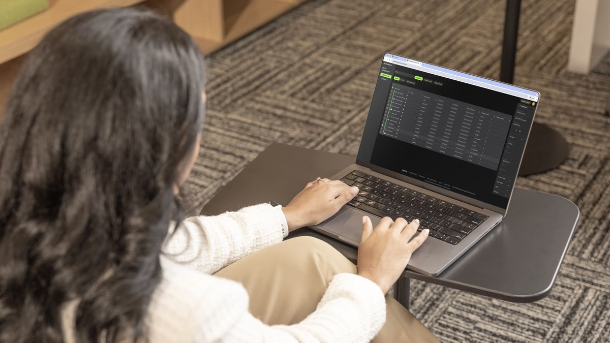 A woman typing on a computer using ShureCloud. 