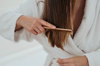 A close up of a woman brushing through her wet hair.