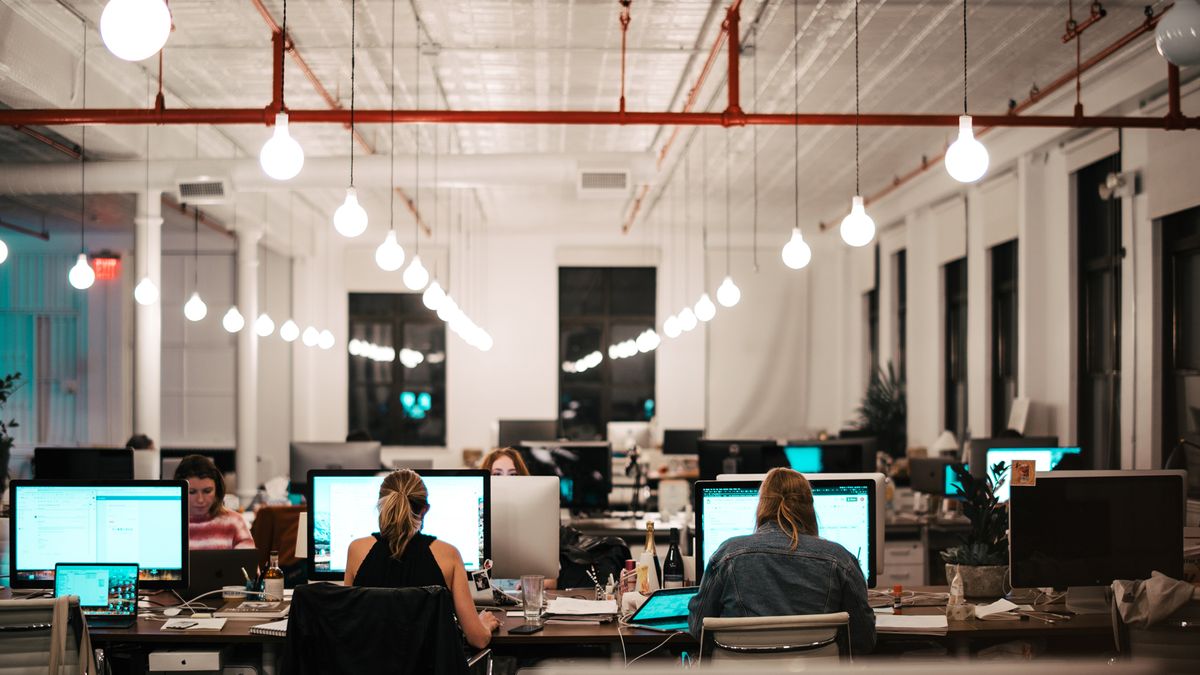 workers in office at desks with computers