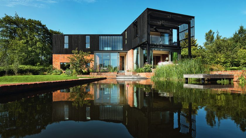 modern two storey L shaped house with large expanse of water in front of property