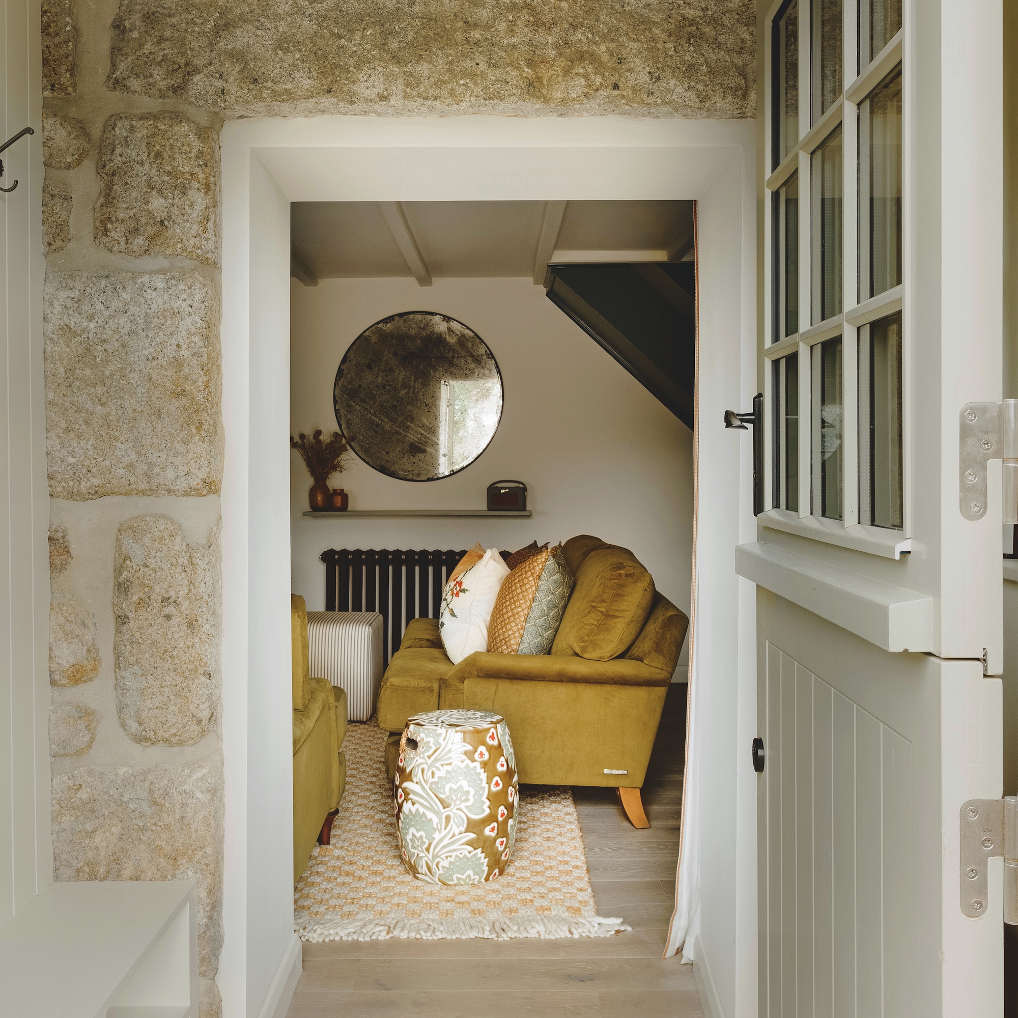 view of sitting room. with green sofa through open door to house