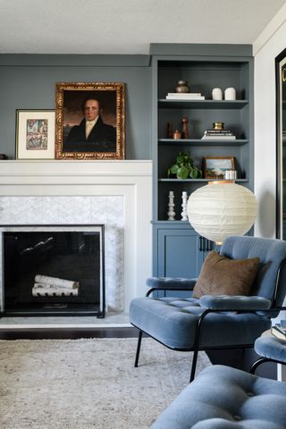Blue armchairs next to a white fire place